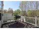 Exterior deck featuring a grill and an outdoor rug overlooking mature trees at 729 Naramore St, Davidson, NC 28036