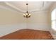 Bright dining area featuring decorative molding, tray ceiling, and hardwood flooring at 729 Naramore St, Davidson, NC 28036
