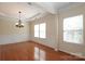 Bright dining room with hardwood floors, chandelier, wainscoting, and large windows at 729 Naramore St, Davidson, NC 28036