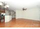 Bright living room showcasing hardwood floors, ceiling fan, and seamless transition to kitchen area at 729 Naramore St, Davidson, NC 28036