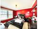 Stylish bedroom with vibrant red walls, comfortable bed, and plenty of natural light from the window at 7928 Ponderosa Pine Ln, Charlotte, NC 28215