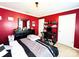 Bright bedroom with vibrant red walls, comfortable bed, and a dedicated workspace at 7928 Ponderosa Pine Ln, Charlotte, NC 28215