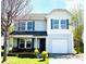 Charming two-story home featuring a covered porch, attached garage, and well-maintained lawn at 7928 Ponderosa Pine Ln, Charlotte, NC 28215