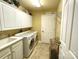 Laundry room with utility sink, white cabinets, washer, dryer, and storage at 811 Wynnshire Dr # A, Hickory, NC 28601
