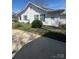 Charming house with vinyl siding, green bushes, and a concrete driveway at 818 N 4Th St, Albemarle, NC 28001