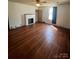 Light-filled living room with polished hardwood floors, neutral walls and decorative fireplace at 818 N 4Th St, Albemarle, NC 28001