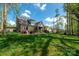 Brick home featuring a large backyard with a covered patio and an outdoor seating area at 8209 Bella Vista Ct, Charlotte, NC 28216