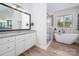 Bright bathroom with a soaking tub and a separate glass-enclosed shower at 8209 Bella Vista Ct, Charlotte, NC 28216