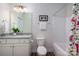 This bathroom offers a single sink vanity with granite counters, a shower-tub combo with white tile, and wood-look flooring at 8209 Bella Vista Ct, Charlotte, NC 28216
