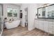 Bright bathroom with a soaking tub and a separate glass-enclosed shower at 8209 Bella Vista Ct, Charlotte, NC 28216