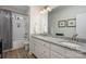Bathroom featuring double sink vanity with granite counters, tub-shower combo with white subway tile and wooden-look flooring at 8209 Bella Vista Ct, Charlotte, NC 28216