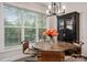 Dining area with large windows, a decorative display cabinet, and a copper-colored dining table at 8209 Bella Vista Ct, Charlotte, NC 28216