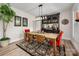 Well-lit dining room with a wooden table, red velvet chairs, floral rug, and stylish bar cabinet at 8209 Bella Vista Ct, Charlotte, NC 28216