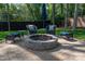 A paver patio features a cozy stone fire pit, comfortable seating, and lush greenery, perfect for outdoor gatherings at 8209 Bella Vista Ct, Charlotte, NC 28216