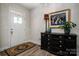 Elegant foyer featuring a decorative front door, stylish console table, and eye-catching artwork at 8209 Bella Vista Ct, Charlotte, NC 28216
