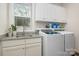 Functional laundry room boasts a washer, dryer, sink, and storage cabinets for an organized space at 8209 Bella Vista Ct, Charlotte, NC 28216