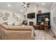 Open-concept living room with cozy seating, fireplace, large TV, ceiling fan, and hardwood floors at 8209 Bella Vista Ct, Charlotte, NC 28216