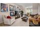 This living room features a comfortable sofa, chair and a tv with several movie posters on the wall at 8209 Bella Vista Ct, Charlotte, NC 28216
