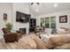 Cozy living room with plush seating, fireplace, a high ceiling with a ceiling fan, and ample natural light at 8209 Bella Vista Ct, Charlotte, NC 28216