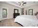 Spacious main bedroom with a large bed, dark wood dresser, multiple mirrors, and a door to the exterior at 8209 Bella Vista Ct, Charlotte, NC 28216