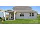 View of the backyard and outdoor patio of this two-story home with large windows at 825 Hallman Branch Ln, Lincolnton, NC 28092