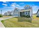 Beautiful home with blue siding, complemented by a lush green lawn at 8718 Festival Way, Charlotte, NC 28215