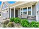 Cozy front porch with a comfortable chair and beautifully landscaped surroundings at 8718 Festival Way, Charlotte, NC 28215
