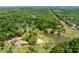 Overhead shot of lot showing trees, pond, surrounding forest, and neighboring homes at 8805 Wingard Dr, Waxhaw, NC 28173