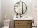 Modern powder room featuring stylish round mirror, vanity, and hardware at 8805 Wingard Dr, Waxhaw, NC 28173