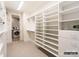 Walk in closet features built in shelving, carpet flooring, and a doorway to the laundry room at 8805 Wingard Dr, Waxhaw, NC 28173