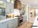 Gourmet kitchen with custom cabinets, marble countertops, stainless steel appliances, and a decorative range hood at 8805 Wingard Dr, Waxhaw, NC 28173