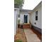 Rear exterior entrance featuring wood steps and a concrete path, with a door that has glass from top to bottom at 904 Brook St, Belmont, NC 28012