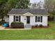 Charming single-story home with a well-manicured lawn and classic curb appeal, complete with dark shutters and light-colored siding at 904 Brook St, Belmont, NC 28012