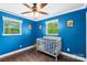 room painted a bright blue with ceiling fan, and a gray crib with colorful graphics at 1099 S Potter Rd, Lancaster, SC 29720