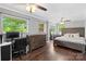 Well-lit primary bedroom with wood floors, crown molding, ceiling fan, large bed, dresser, and expansive view into the backyard at 1099 S Potter Rd, Lancaster, SC 29720