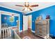 room painted a bright blue featuring a dresser, closet, and a gray crib with colorful graphics at 1099 S Potter Rd, Lancaster, SC 29720