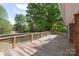 A spacious wooden deck offers ample outdoor living space, surrounded by mature trees and greenery at 1099 S Potter Rd, Lancaster, SC 29720
