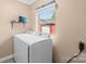 Bright laundry room with white washer and dryer, window, and overhead shelf at 1099 S Potter Rd, Lancaster, SC 29720