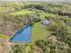 Aerial shot showcases a home nestled amidst trees with a sizable pond, combining nature and comfort at 1151 Trull Hinson Rd, Wingate, NC 28174