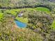 Aerial perspective of a home with a tranquil pond in a verdant setting, blending nature and home at 1151 Trull Hinson Rd, Wingate, NC 28174