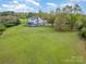 A captivating aerial perspective of the estate showcasing lush greenery and a charming two-story house at 1151 Trull Hinson Rd, Wingate, NC 28174