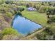 Overhead view of a house with a large private pond surrounded by trees, offering a peaceful retreat at 1151 Trull Hinson Rd, Wingate, NC 28174