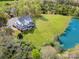Aerial view of a charming home featuring a serene pond, large yard, and inviting screened-in porch at 1151 Trull Hinson Rd, Wingate, NC 28174