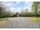 View of a rustic barn with a gravel driveway, set in a scenic countryside environment at 1151 Trull Hinson Rd, Wingate, NC 28174