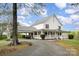 Expansive white house with a sprawling front porch and an attached carport, perfect for outdoor living at 1151 Trull Hinson Rd, Wingate, NC 28174