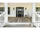Cozy front porch featuring a black front door, classic rocking chair, and decorative outdoor lanterns at 1151 Trull Hinson Rd, Wingate, NC 28174