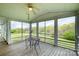 Cozy screened-in porch with wooden floors, a ceiling fan, and serene views of a lush pond at 1151 Trull Hinson Rd, Wingate, NC 28174