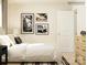 Inviting bedroom with white bedding, vintage car art, and a light wood dresser at 1202 Blackburn Cir, Edgemoor, SC 29712