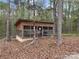 Rustic chicken coop in a wooded setting, surrounded by mature trees, perfect for hobby farmers at 13079 Philadelphia Church Rd, Oakboro, NC 28129