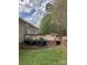 Side yard with a wooden deck, brick foundation, and landscaped garden bed at 13079 Philadelphia Church Rd, Oakboro, NC 28129